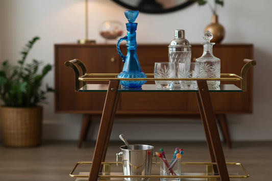 A vintage blue glass genie bottle decanter with a handle and cork stopper.