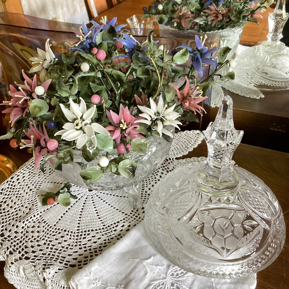 Vintage clear glass collectibles styled throughout a home — bar cart, windowsill, terrarium, and seasonal displays