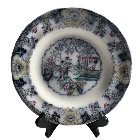 Decorative ceramic plate with intricate designs on a stand against a white background