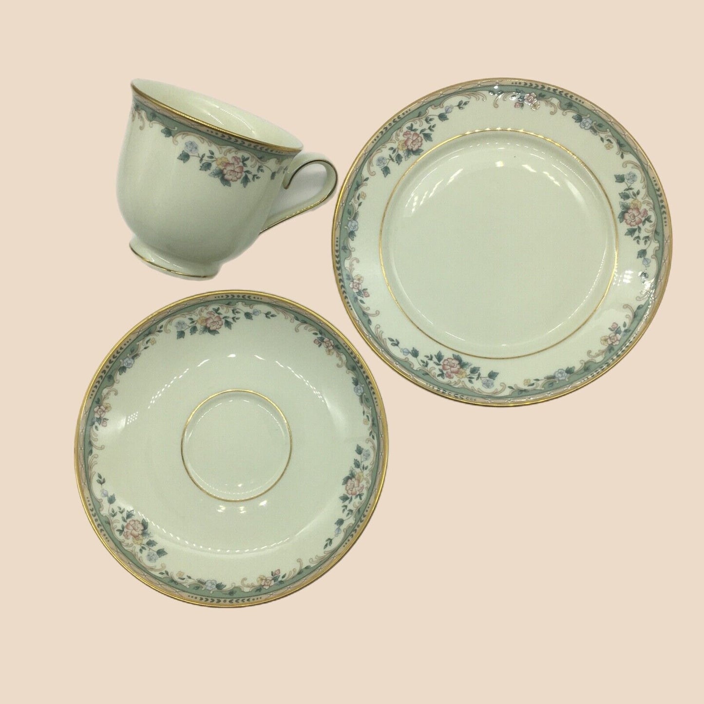 Teacup and saucers with floral patterns on a light pink background