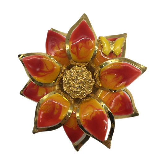 Decorative brooch with red, orange, and gold colors on a white background