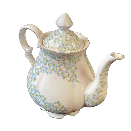 Decorative teapot with floral pattern on a white background
